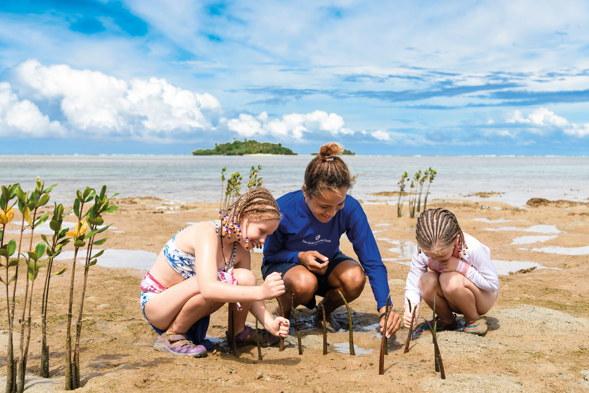 All-inclusive-family-resort-2-Fiji-Kids-Eco-Programmes Children with a resident Marine Biologist planting mangrove seedlings as part of Kids Eco-Programmes at Jean-Michel Cousteau Resort Fiji, an all-inclusive family resort in Fiji.