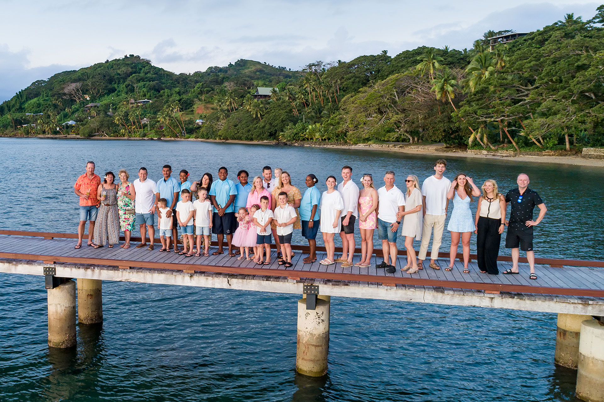 Families-5-luxury-family-vacation-in-fiji A multigenerational family posing with Jean-Michel Cousteau Resort Fiji staff while on their family vacation in Fiji.